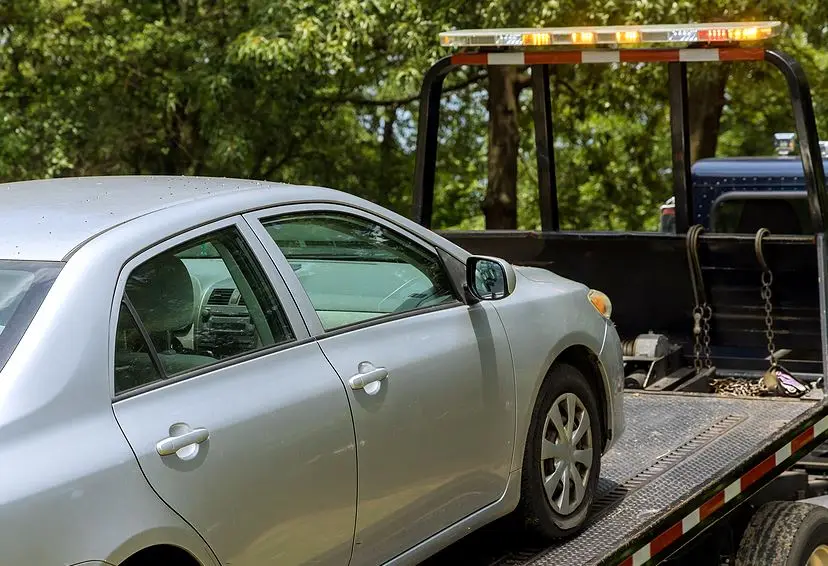Sedan loaded on a flatbed tow truck