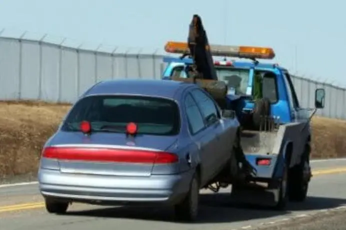 Car lifted by a wheel lift tow truck